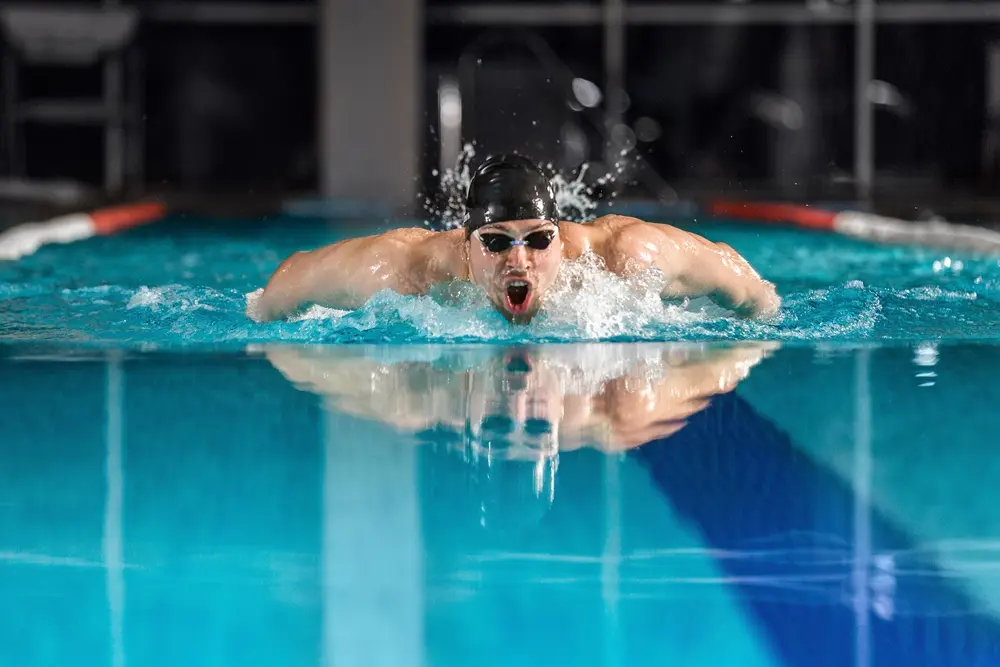 Homem em uma piscina praticando natação - Top 5 smartwatch para natação com GPS.
