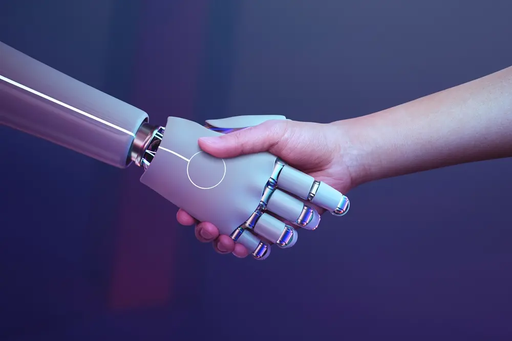 mão robótica e mão humana se cumprimentando. 