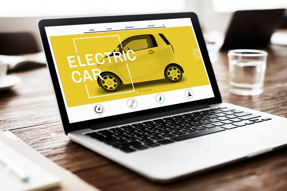Um laptop exibindo um site vibrante sobre carros elétricos, com uma ilustração de um carro amarelo em um fundo amarelo.