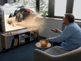 Uma pessoa assistindo TV na sala e comendo um petisco.