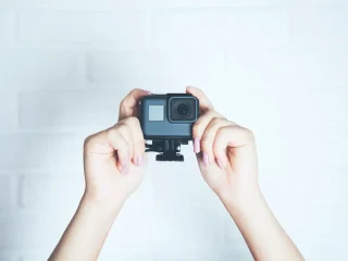 Mãos de uma mulher segurando uma câmera de ação.