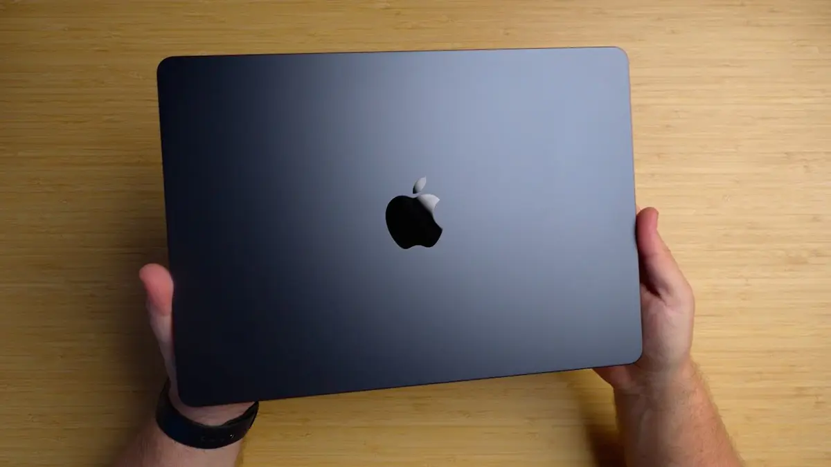 uma pessoa segurando o apple macbook air m2 cor grafite