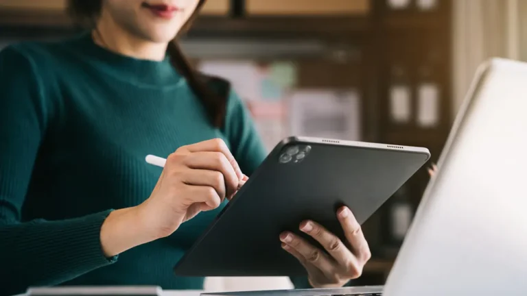Uma mulher segurando um tablet e uma caneta