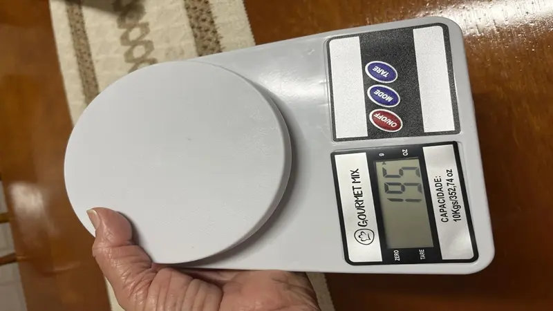 Mão pressionando botão Tara em balança digital de cozinha - Resenha Balança Digital 10kg.