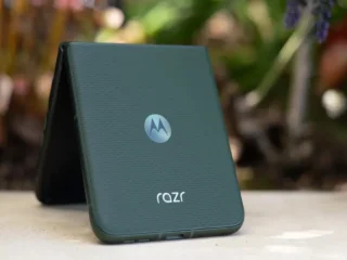 Celular Moto Razr cor verde sobe uma mesa branca em destaque.