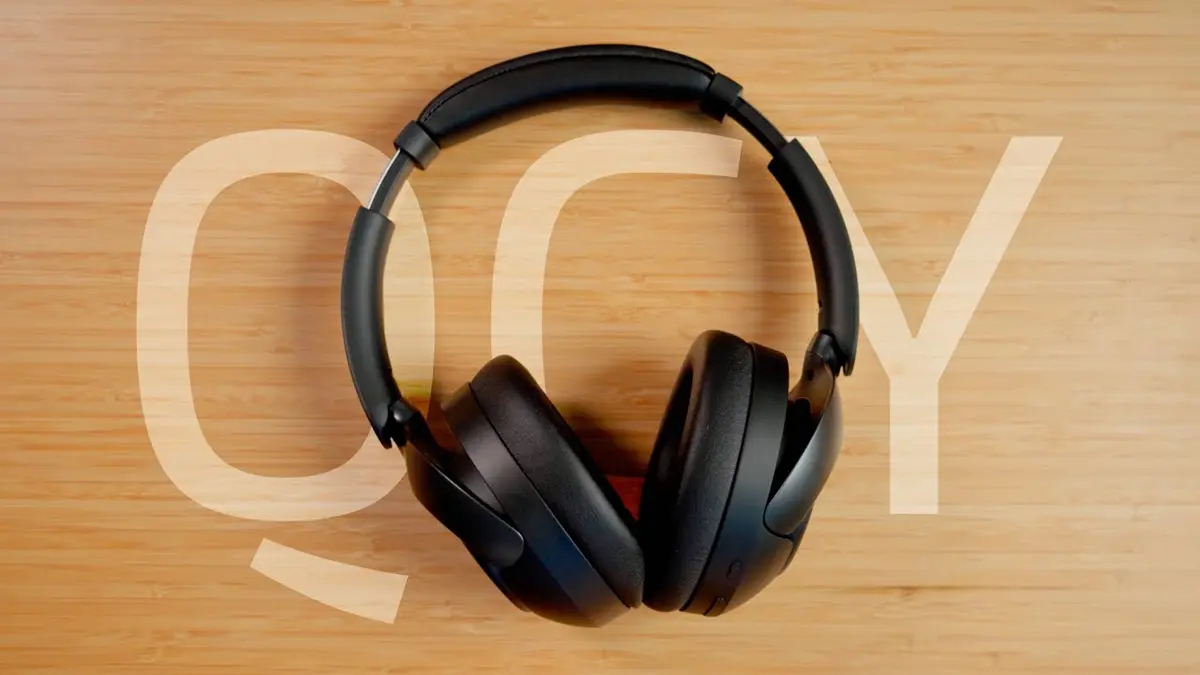 QCY H3 Pro sobe uma mesa de madeira.
