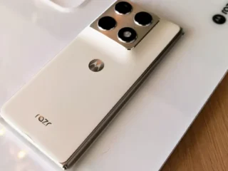Motorola Razr Fold 70 cor branco sobe uma mesa de madeira.