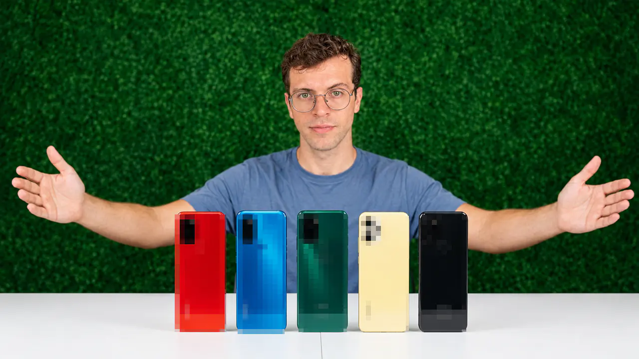 Uma pessoa cabelo cacheado curto usando oculos, atrás de um balcão com 5 Celular Gamer Baratos dispostos