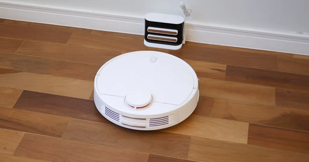Robô aspirador Xiaomi s10 cor branco aproximando da sua base de carregamento.