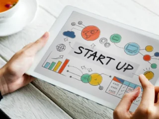 Mãos segurando uma placa escrito startup