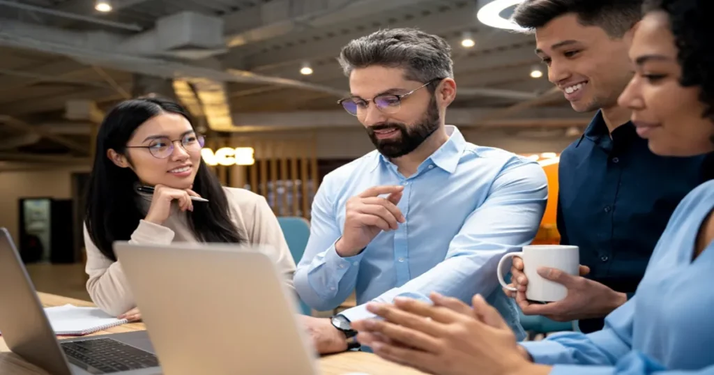 Startup vs Empresa Tradicional quatro pessoa em uma sala de escritório.