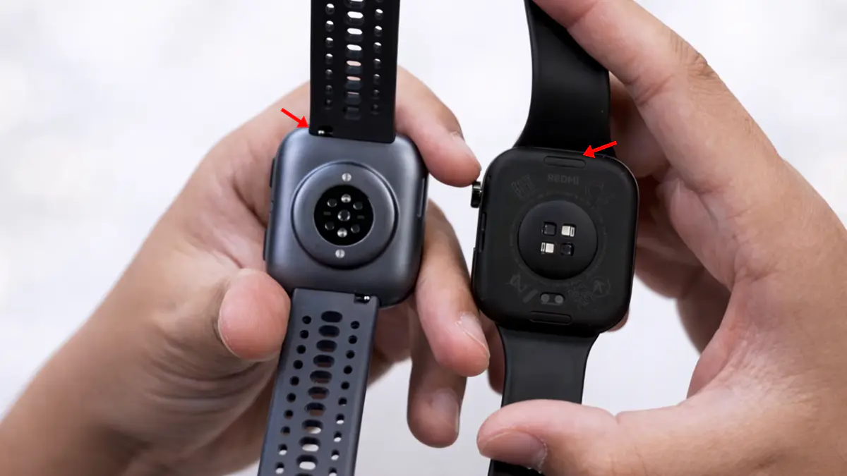 Uma pessoa segurando um smartwatch em cada mão exibindo sua parte de sensores em um fundo branco.