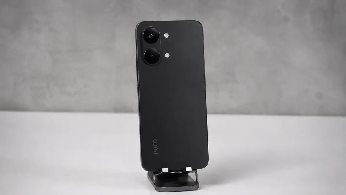 Os Únicos 5 Celulares Xiaomi Quem Valem a Pena Comprar em 2026 2 Smartphone Poco X8 Pro Max cor preto em um suporte fixo sobre uma bancada cor branca em um fundo cinza desfocado.