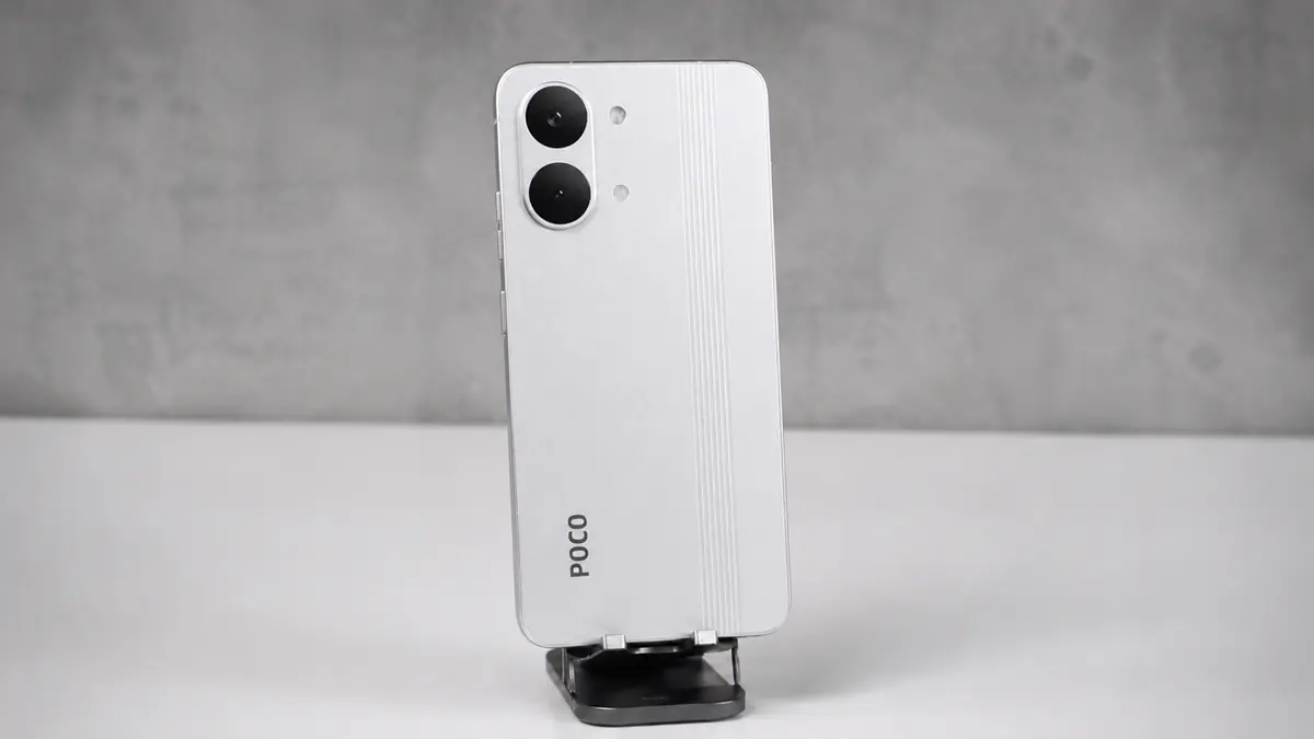 Os Únicos 5 Celulares Xiaomi Quem Valem a Pena Comprar em 2026 3 Smartphone Poco X8 Pro cor branco em um suporte fixo sobre uma bancada cor branca em um fundo cinza desfocado.