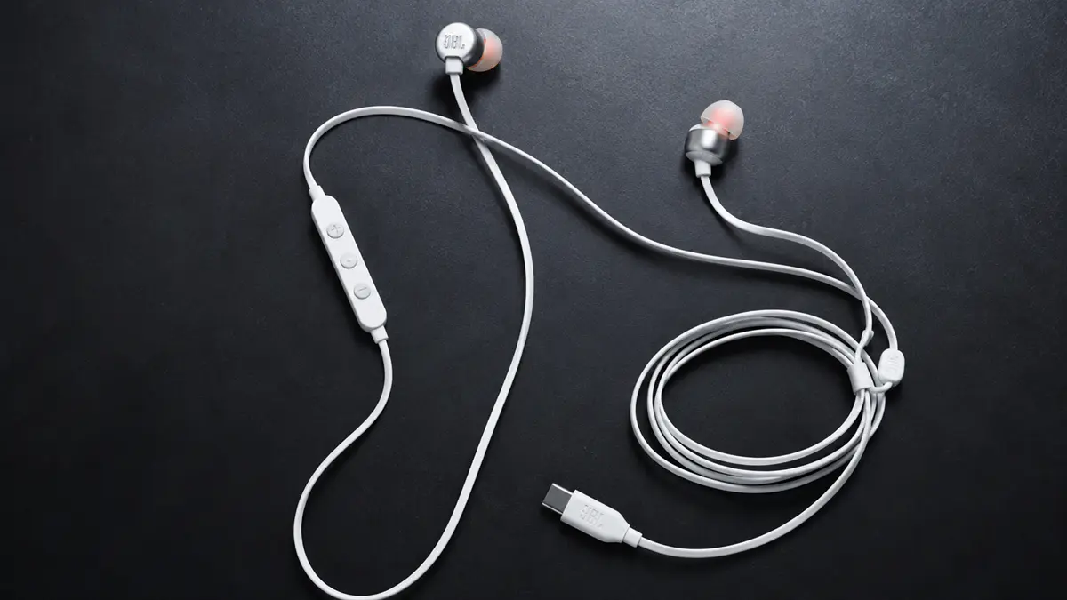 Imagem cinamatic de um fone com fio tipo c modelo JBL Tune 310C em um fundo escuro.