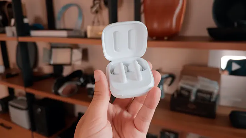 QCY T13 ANC 2026: Vale a Pena? Review Honesto 4 Mão segurando a case do fone bluetooth qcy t13 anc cor branco.