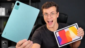 Uma pessoa segurando o tablet Redmi Pad SE cor azul na mão direita e caixa na mão esquerda.
