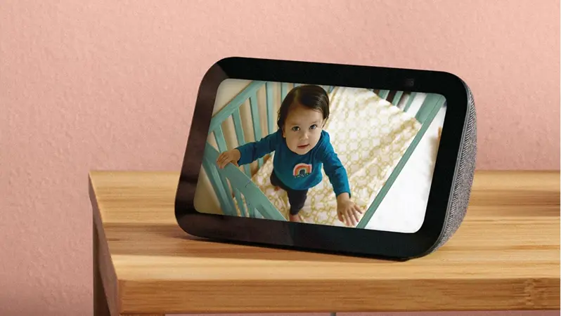 Assistente de voz Echo Show 5 sobe uma mesa de madeira.
