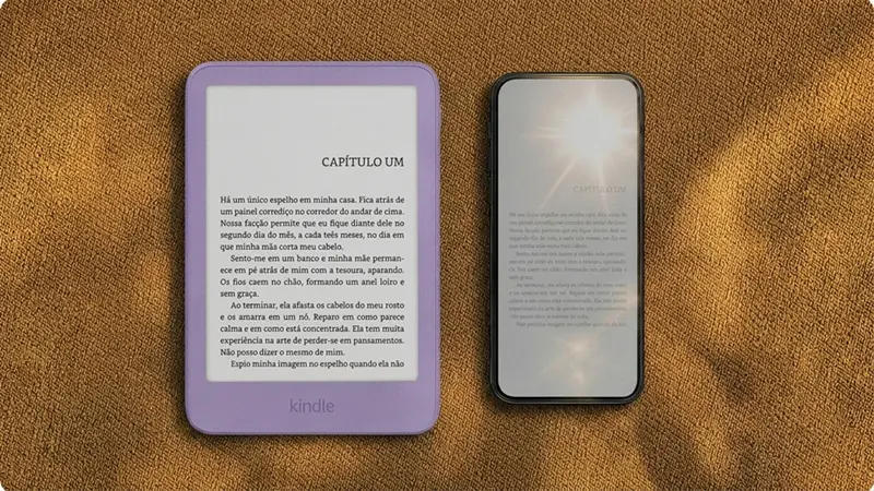 Um Kindle 16 GB ao lado de um smartfone exibindo a página de um livro.