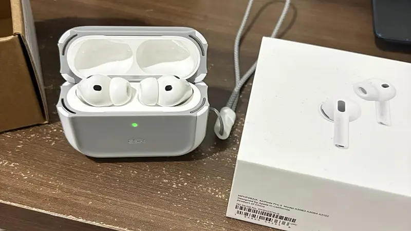Case com os fones AirPods Pro 3 sobe uma mesa de madeira.