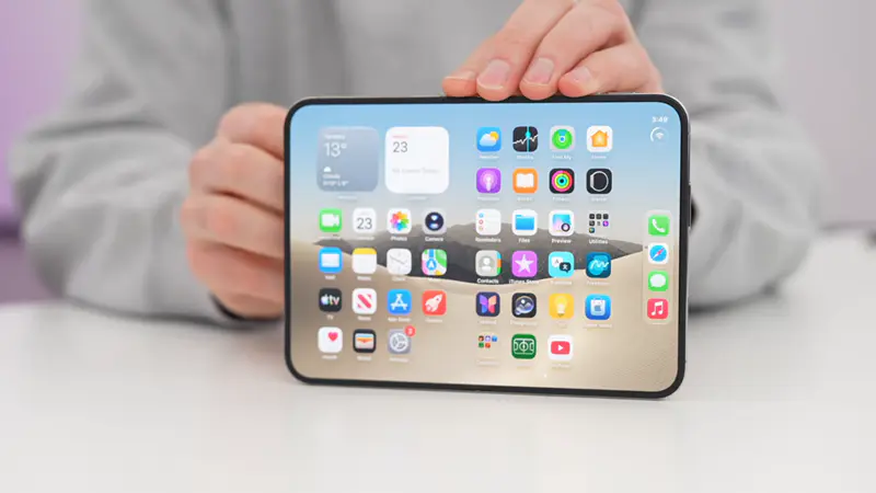 Uma pessoa segurando o iphone duo com a tela aberta em uma bancada.