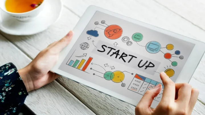Mãos segurando uma placa escrito startup
