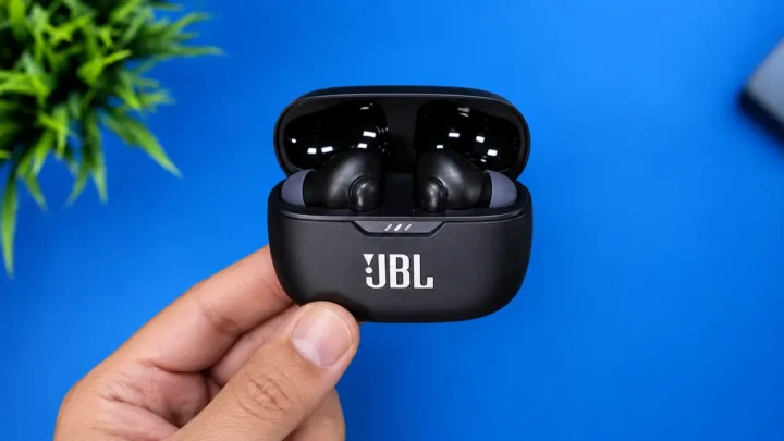 Uma pessoa segurando a case do fone de ouvido JBL WAVE Beam 2 em um fundo azul
