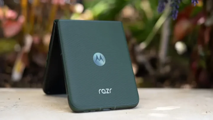 Celular Moto Razr cor verde sobe uma mesa branca em destaque.
