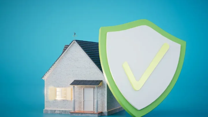Uma pequena casa ao lado de um grande escudo verde e branco com uma marca de seleção, simbolizando proteção e segurança do lar.