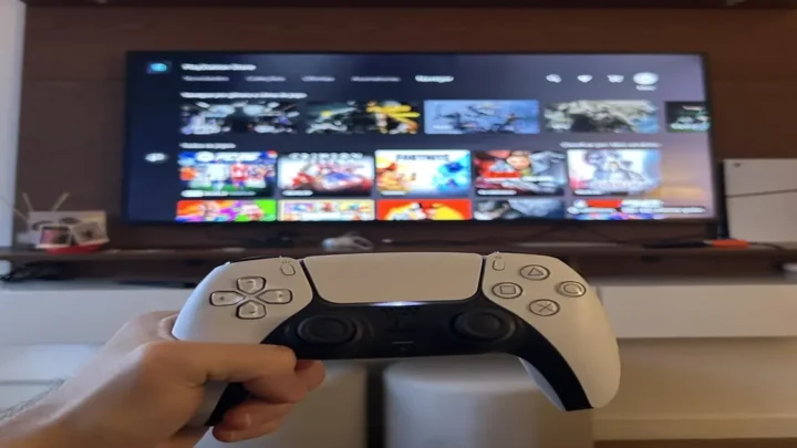 DRM Playstation, mão segurando joystick dual shock cor branco ao fudo tela inicial jogo.