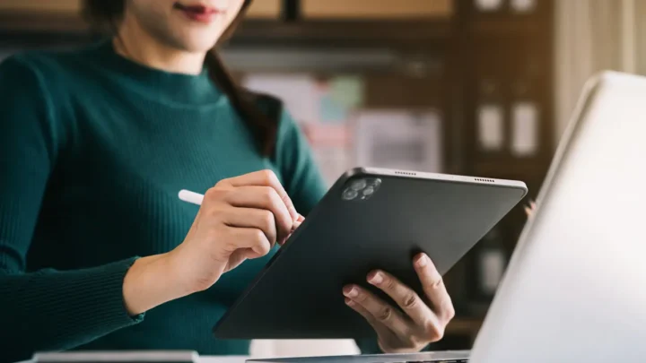 Uma mulher segurando um tablet e uma caneta